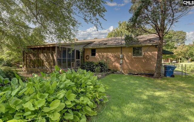 back of house with a lawn and a sunroom