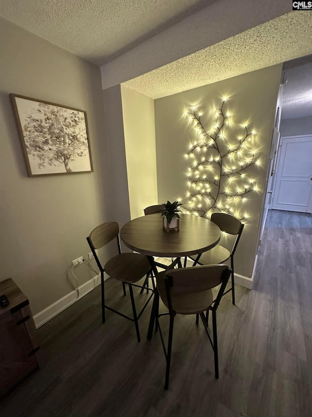 dining area with a textured ceiling and dark hardwood / wood-style floors