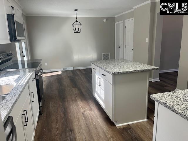 kitchen with white cabinets, a center island, hanging light fixtures, light stone counters, and electric range