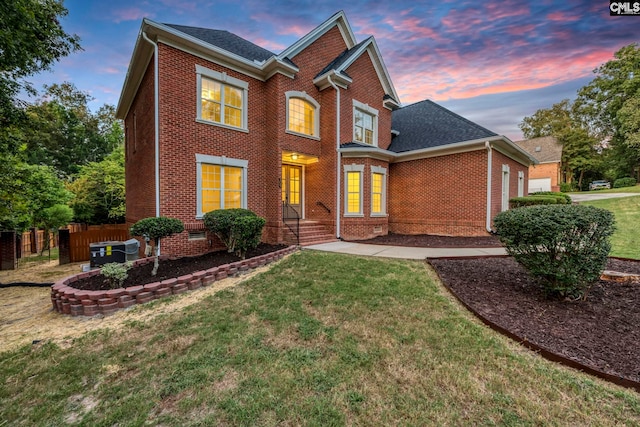 view of front of property featuring a yard, central AC unit, and a patio area