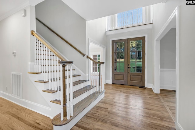 entryway featuring a high ceiling, french doors, and hardwood / wood-style floors