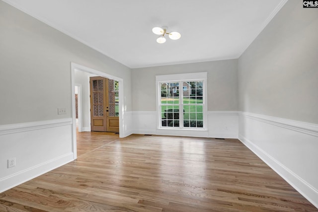 spare room with light hardwood / wood-style floors and french doors