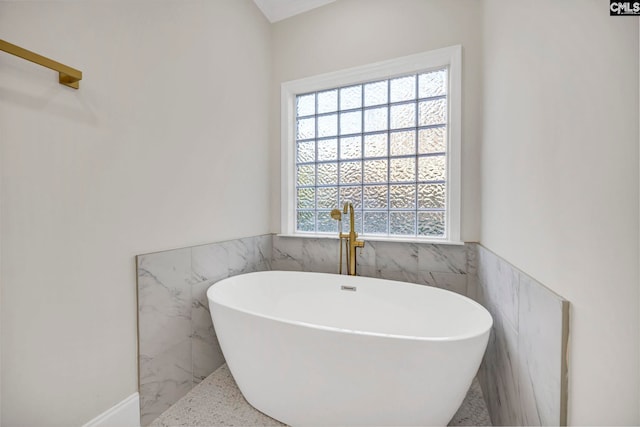 bathroom with tile walls and a bathtub