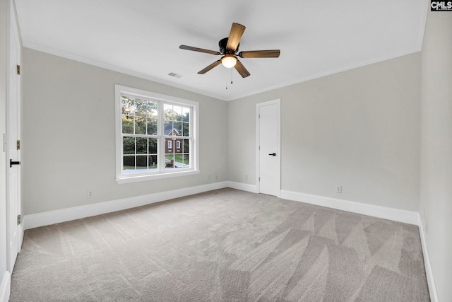 carpeted empty room with ceiling fan and crown molding