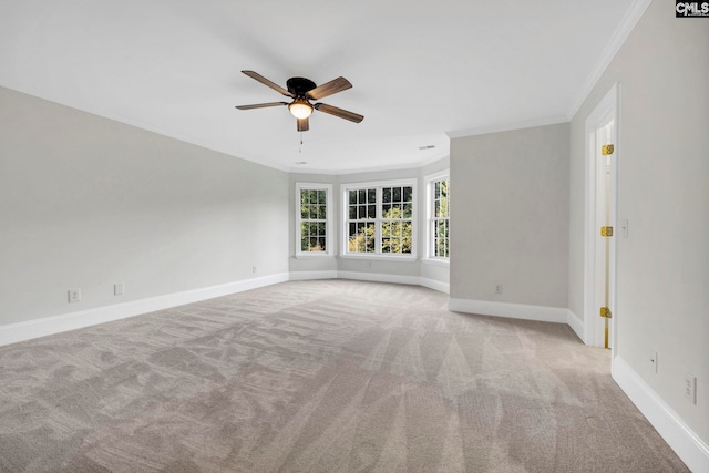 unfurnished room featuring light colored carpet, ceiling fan, and crown molding