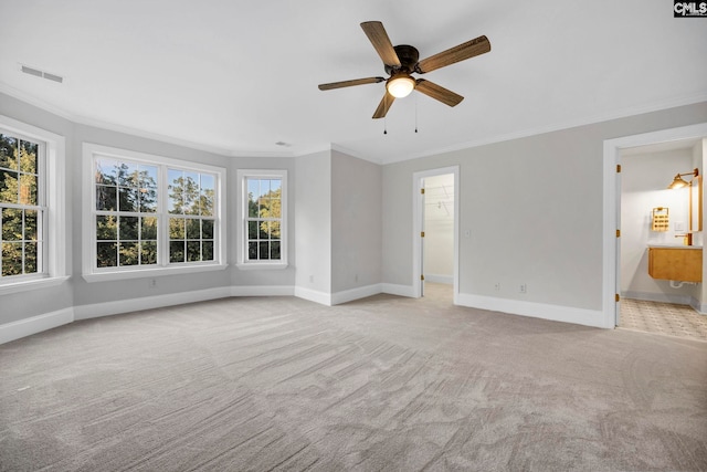 carpeted empty room featuring ornamental molding, ceiling fan, and a healthy amount of sunlight