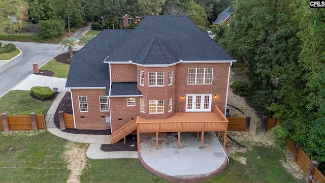 rear view of house with french doors and a yard