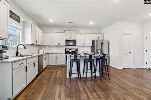 kitchen featuring sink, stainless steel appliances, a center island, and white cabinetry