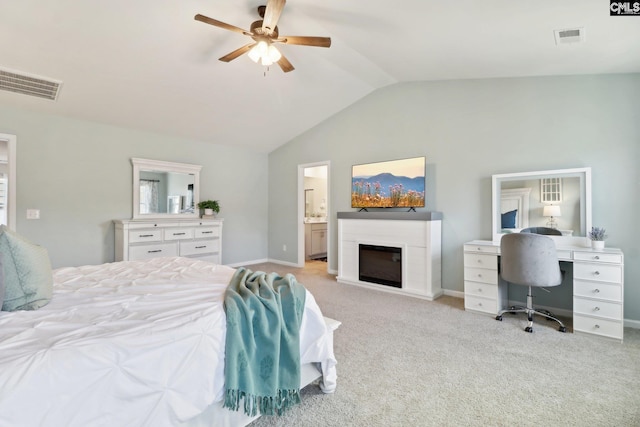 bedroom featuring light carpet, a glass covered fireplace, visible vents, and lofted ceiling