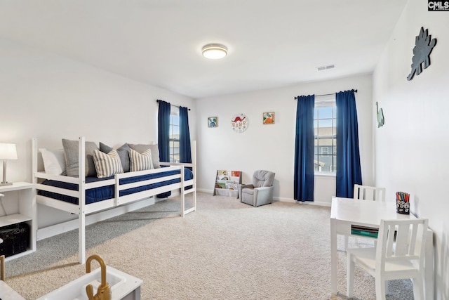 carpeted bedroom with baseboards, multiple windows, and visible vents