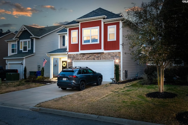 view of front of property with a garage, stone siding, a yard, and concrete driveway