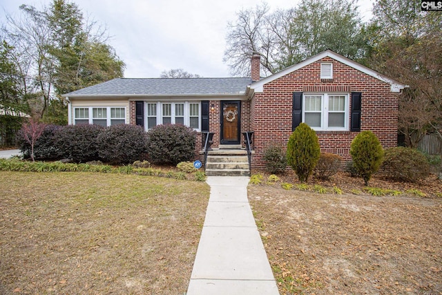 bungalow-style home with a front yard