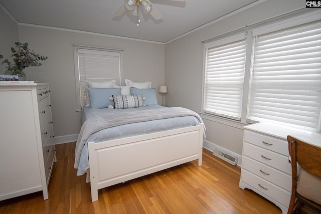 bedroom featuring ornamental molding, light wood-type flooring, ceiling fan, and multiple windows