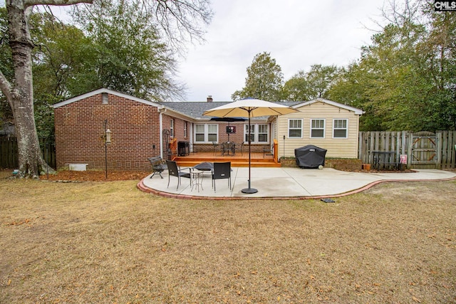 rear view of house featuring a lawn and a patio