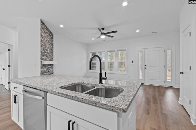 kitchen featuring dishwasher, light stone countertops, sink, and white cabinets