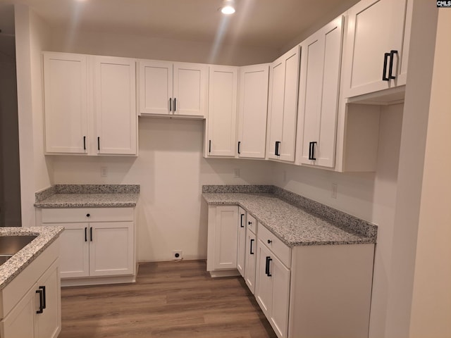 kitchen featuring white cabinetry, light stone counters, and dark hardwood / wood-style floors