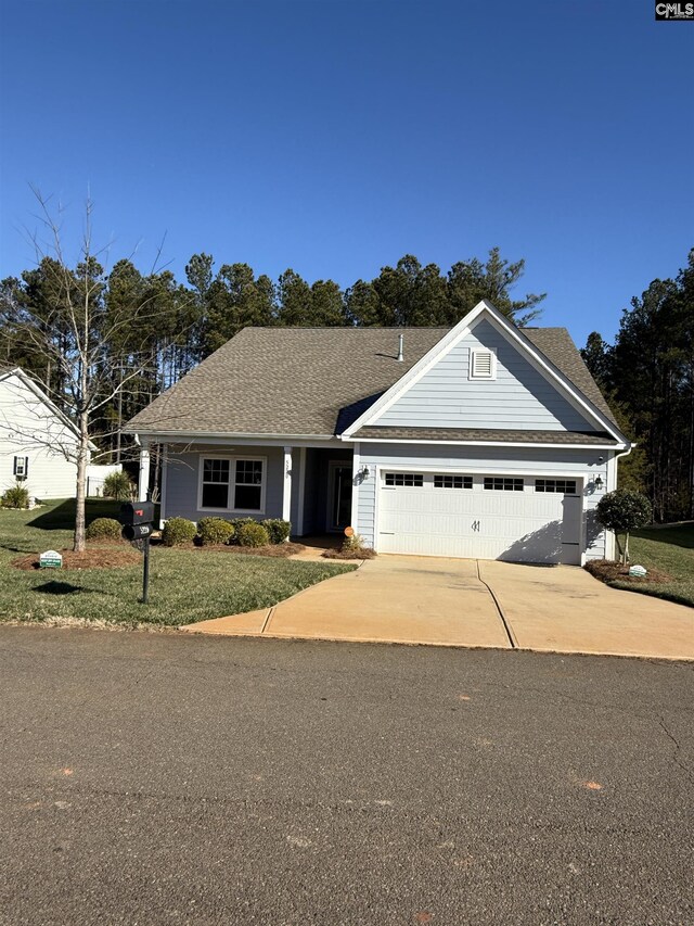 view of front of property featuring a front lawn and a garage