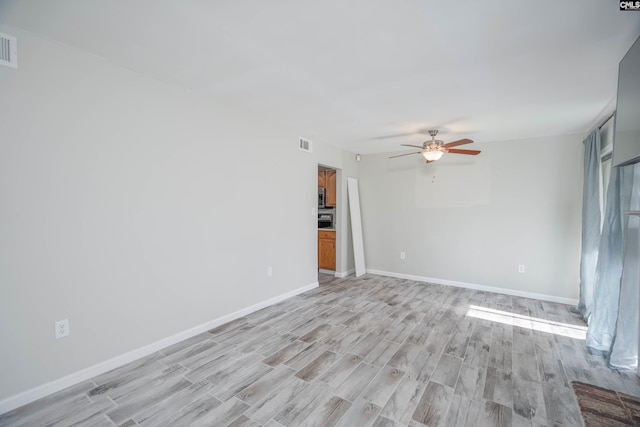 empty room with ceiling fan and light wood-type flooring