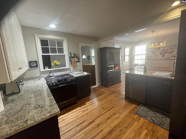 kitchen with black gas range, an inviting chandelier, light wood-type flooring, dark brown cabinets, and sink