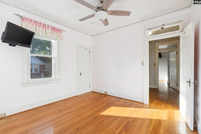 empty room with ceiling fan and hardwood / wood-style flooring