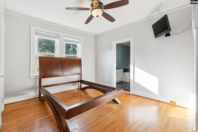 bedroom featuring ceiling fan, ensuite bathroom, crown molding, and hardwood / wood-style flooring