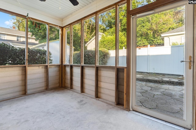 unfurnished sunroom featuring ceiling fan