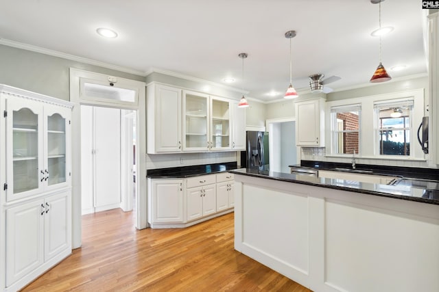 kitchen featuring stainless steel fridge with ice dispenser, white cabinets, tasteful backsplash, and decorative light fixtures