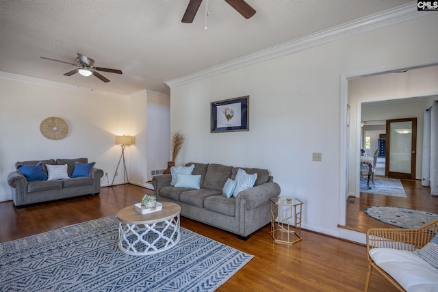 living room with ceiling fan, hardwood / wood-style floors, ornamental molding, and a textured ceiling