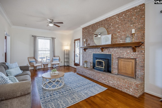 living room with ceiling fan, wood-type flooring, ornamental molding, and a textured ceiling