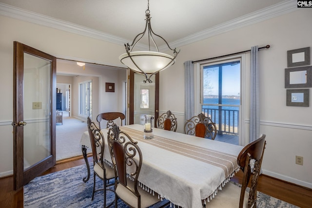 dining room with a water view, french doors, dark hardwood / wood-style flooring, and ornamental molding