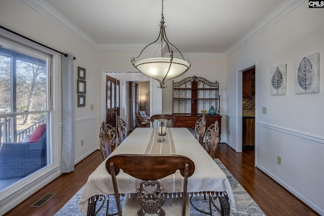 dining room featuring crown molding and dark hardwood / wood-style floors