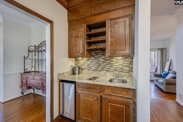 kitchen featuring decorative backsplash, sink, light stone counters, and crown molding