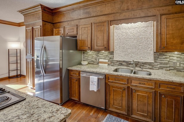 kitchen with light stone countertops, appliances with stainless steel finishes, and sink