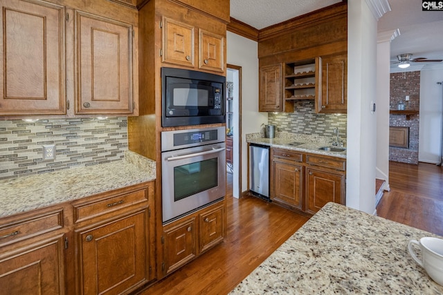 kitchen featuring stainless steel appliances, crown molding, tasteful backsplash, and light stone countertops