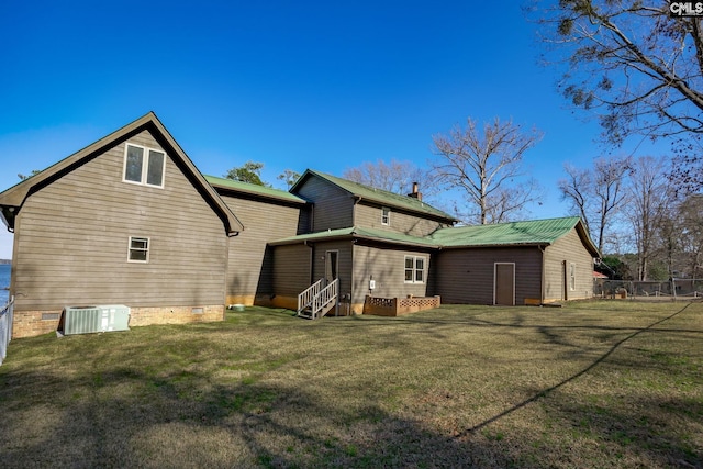 back of property featuring a lawn and central AC