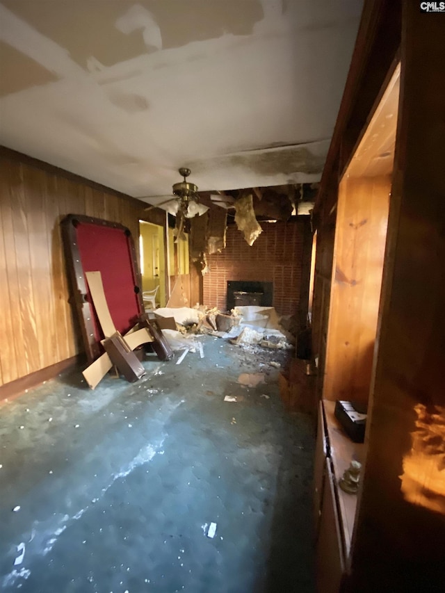 misc room with concrete floors, wood walls, and a fireplace