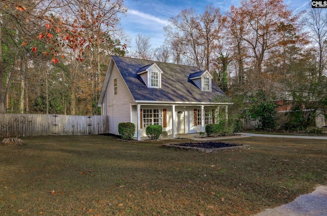 new england style home featuring covered porch and a front yard