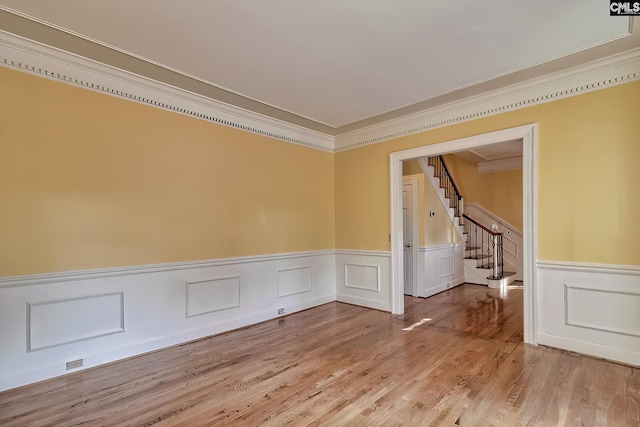 unfurnished room featuring ornamental molding and light wood-type flooring