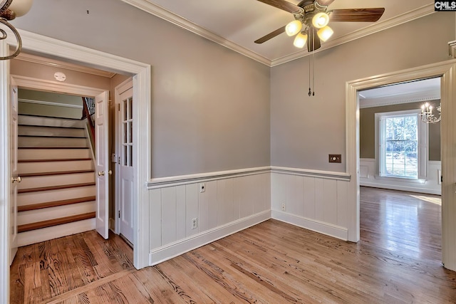 empty room featuring ceiling fan, ornamental molding, and light wood-type flooring