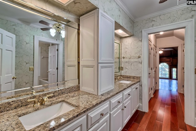 bathroom with ornamental molding, hardwood / wood-style floors, vanity, and ceiling fan