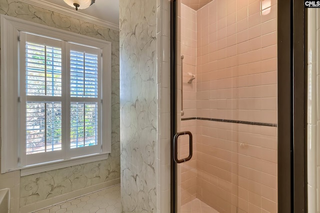 bathroom with crown molding and a shower with shower door