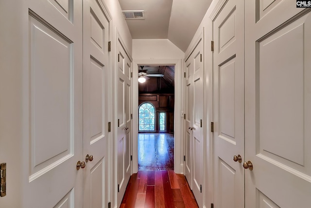 hall with lofted ceiling and hardwood / wood-style flooring