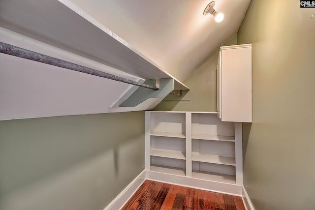 walk in closet featuring dark hardwood / wood-style flooring and lofted ceiling