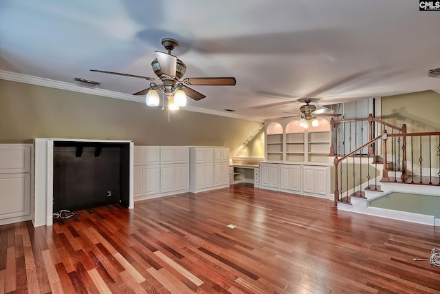 unfurnished living room with hardwood / wood-style flooring, ornamental molding, built in features, and ceiling fan