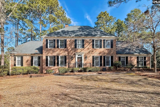 colonial home featuring a front yard