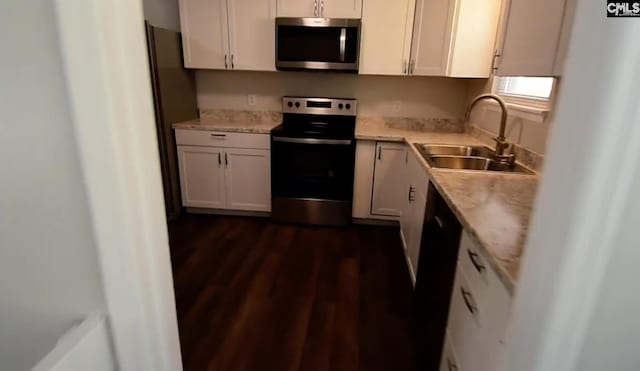 kitchen with dark hardwood / wood-style floors, sink, light stone countertops, stainless steel appliances, and white cabinets