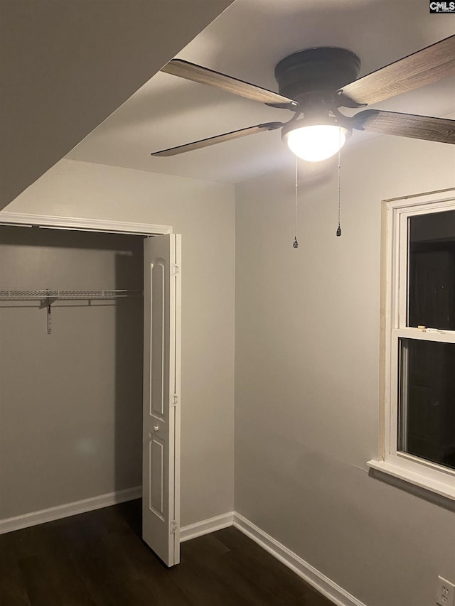 unfurnished bedroom featuring ceiling fan, dark wood-type flooring, and a closet