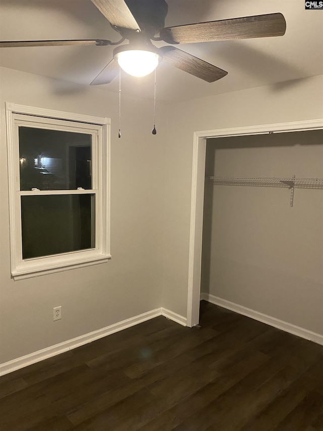 unfurnished bedroom featuring ceiling fan, a closet, and dark wood-type flooring