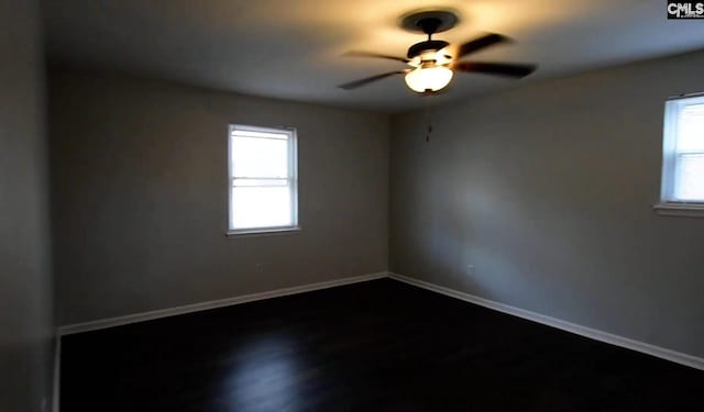 empty room with dark wood-type flooring and ceiling fan