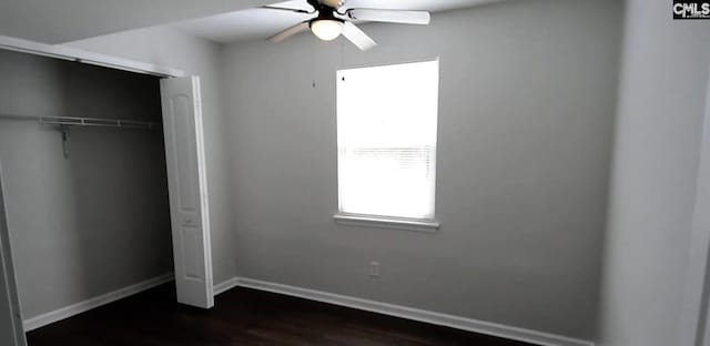 unfurnished bedroom featuring ceiling fan, a closet, and dark hardwood / wood-style flooring